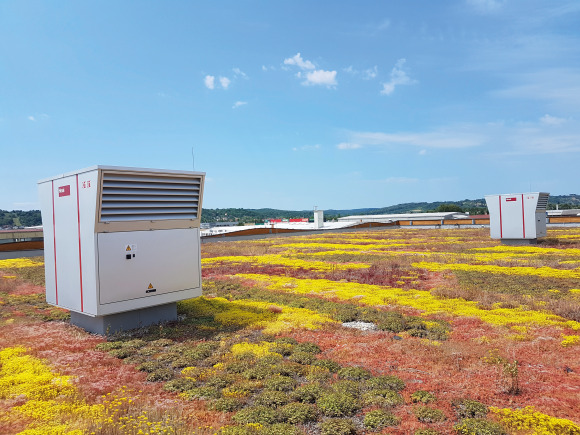Дървената сграда се откроява визуално с два RoofVent® модула в средата на зеления покрив